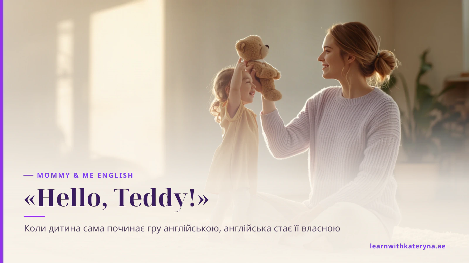 Маленька дівчинка високо піднімає ведмедика, щоб привітатися, а мама з усмішкою сидить поруч на килимі