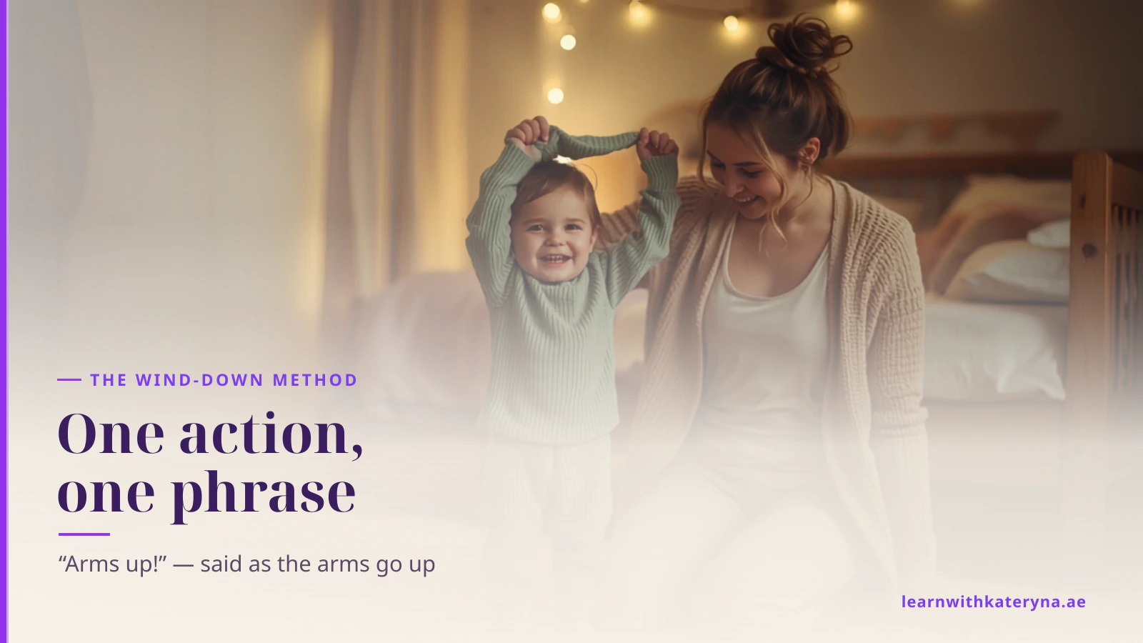 A laughing toddler with both arms up pulls a pyjama top over their head while their mother kneels beside them in a warm, softly lit bedroom