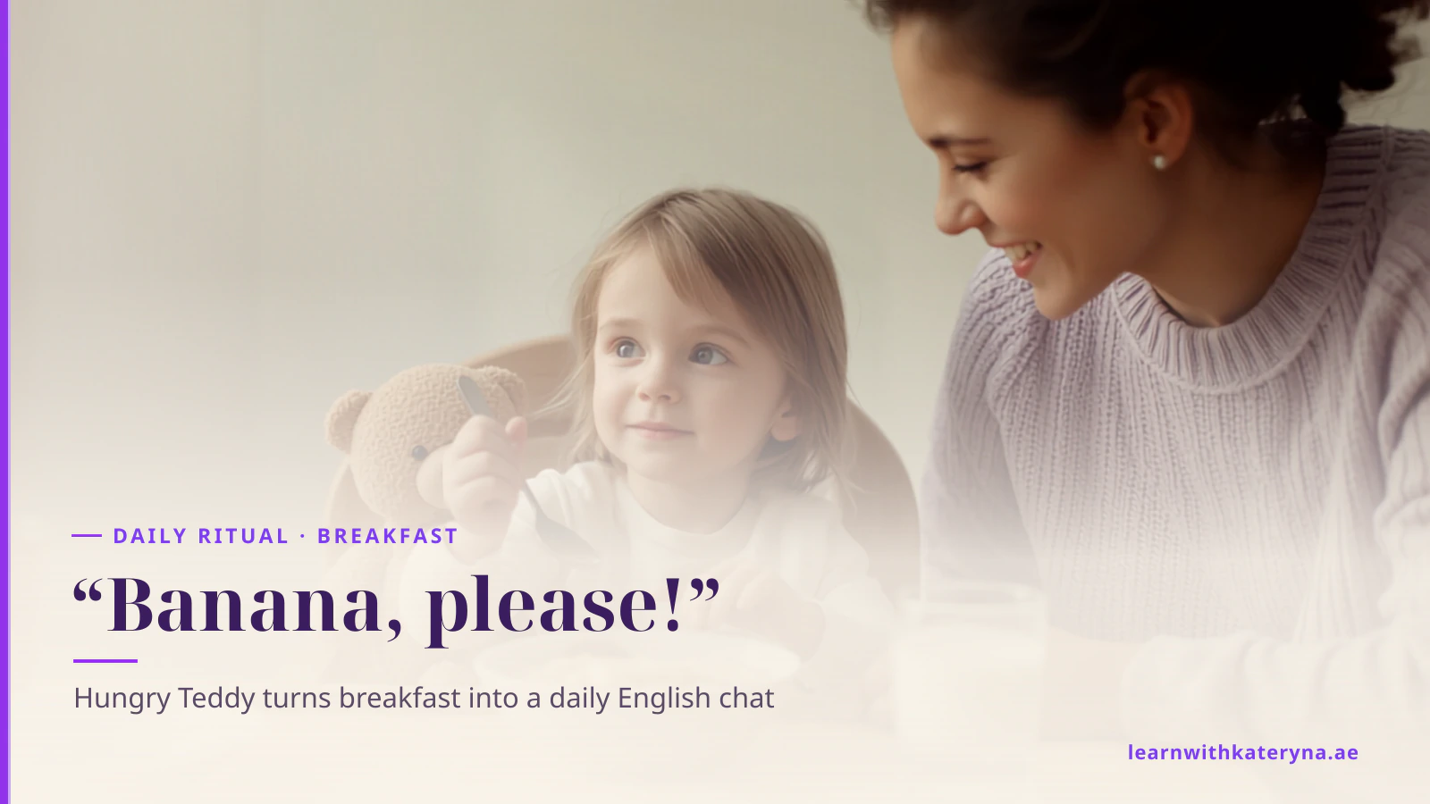 A toddler at the breakfast table holds her spoon out to a teddy bear sitting beside her while her mother smiles at her
